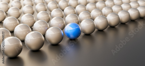 Leadership concept, blue leader ball, standing out from the crowd of silver balls, on black background. 3D Rendering
