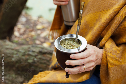 Tableau sur toile Close-up shot of a woman's hands holding a poured steaming yerba mate, a traditional South American infusion
