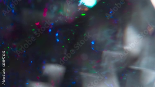 Facets of the Diamond Glow in the Dark. The light passes through the facets of a slowly rotating diamond and creates repetitive sparkling highlights and rainbow colors