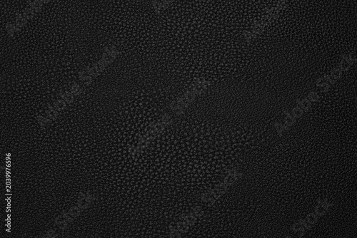Foto black artificial leather with waves and folds on PVC base
