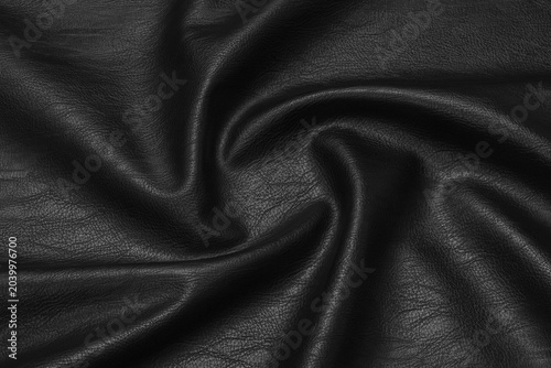 Photos black artificial leather with waves and folds on PVC base