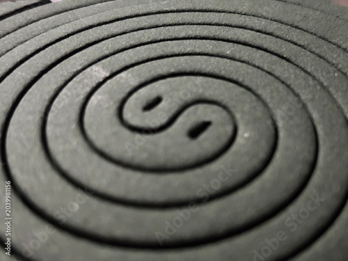 Close up macro shot of a green spiral mosquito repellent coil on dark background. Insect protection concept.
