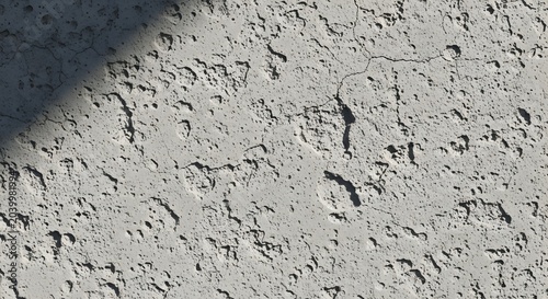 Textured gray concrete wall surface with cracks and diagonal shadow