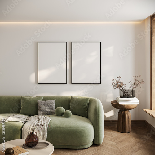 Two blank black poster frame mockups displayed on a modern living room wall above a green sofa with soft sunlight shadows, neutral decor, wooden details and elegant interior styling, 3d rendering