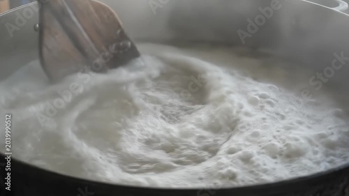 Wooden Spoon Stirring White Rice Porridge in Large Pot