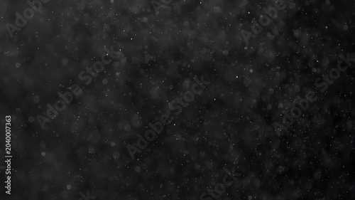 Night Christmas Magic. Small white particles flow in the air on a black background. Slow Motion