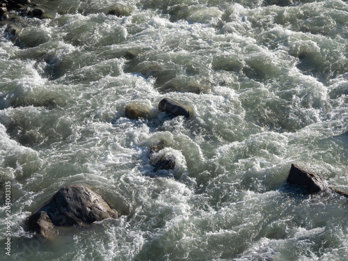 Rushing water crashes over jagged rocks