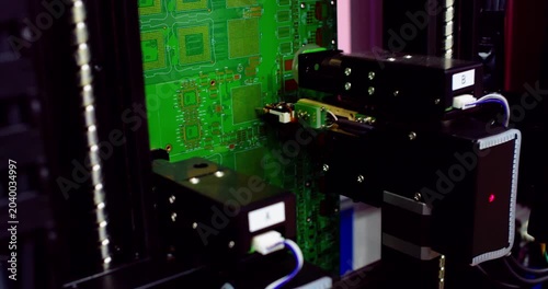 Automated industrial robot tester inspects microchips and components on a motherboard. Closeup of advanced technology, equipment, and digital hardware quality assessment.