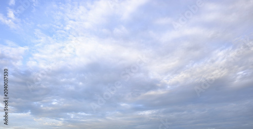 Foto Soft white altocumulus clouds across peaceful bright blue sky background