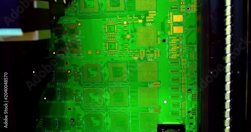 Automated industrial robot tester inspects microchips and components on a motherboard. Closeup of advanced technology, equipment, and digital hardware quality assessment.