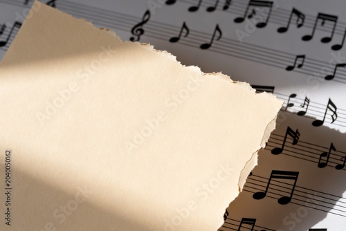 Torn Paper Over Sheet Music with Soft Lighting