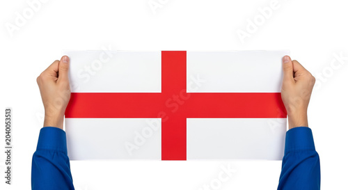 Two hands in blue sleeves holding a white rectangular sign with a red cross, the flag of england, isolated on a black background