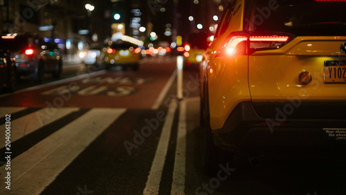 Photos Rear view of yellow taxi stopped in nighttime traffic with brake lights