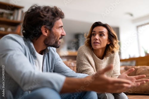 Couple having a serious conversation at home. Man and woman arguing about relationship problems. Conflict and disagreement concept
