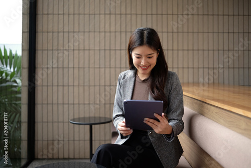 The young woman is checking job announcements on her tablet.