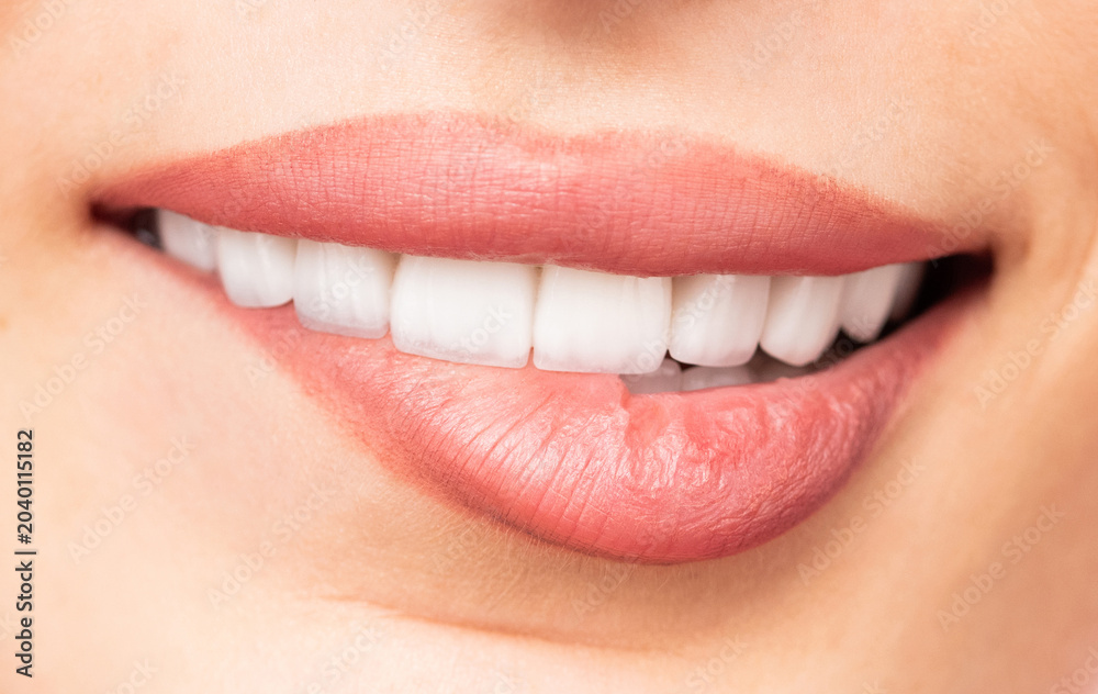 Naklejka premium Human mouth close-up showing white teeth and glossy lips
