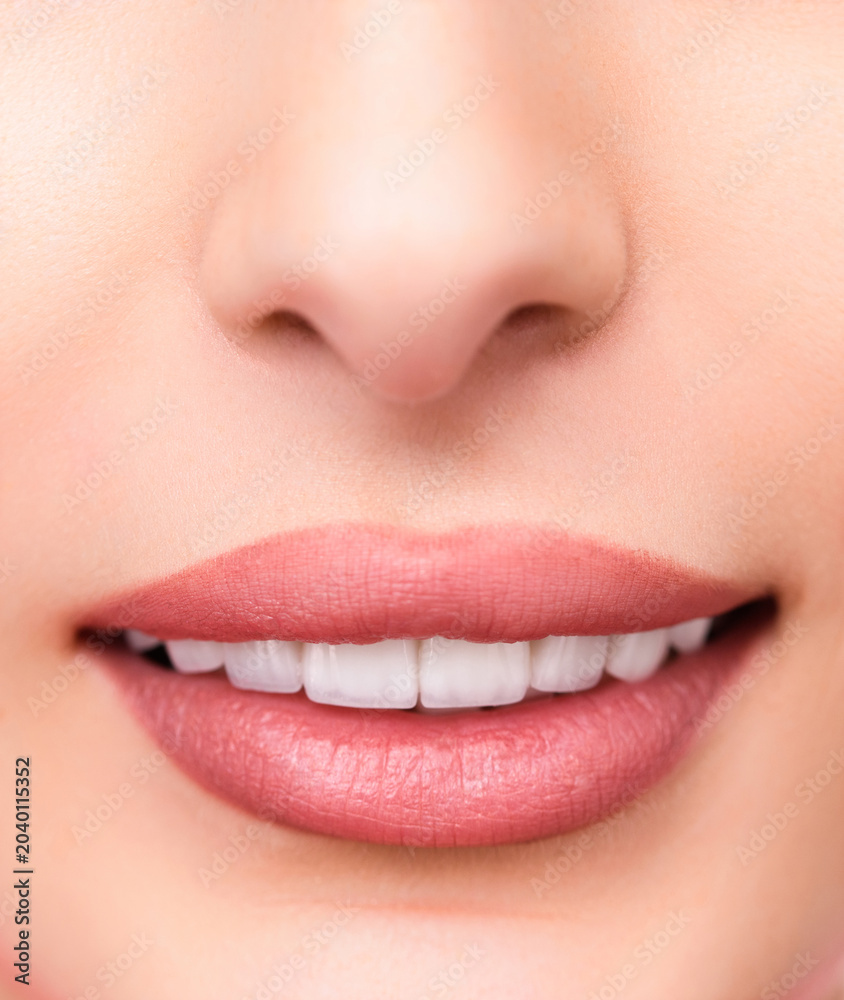 Obraz premium Detailed shot of smiling human lips showing bright white teeth