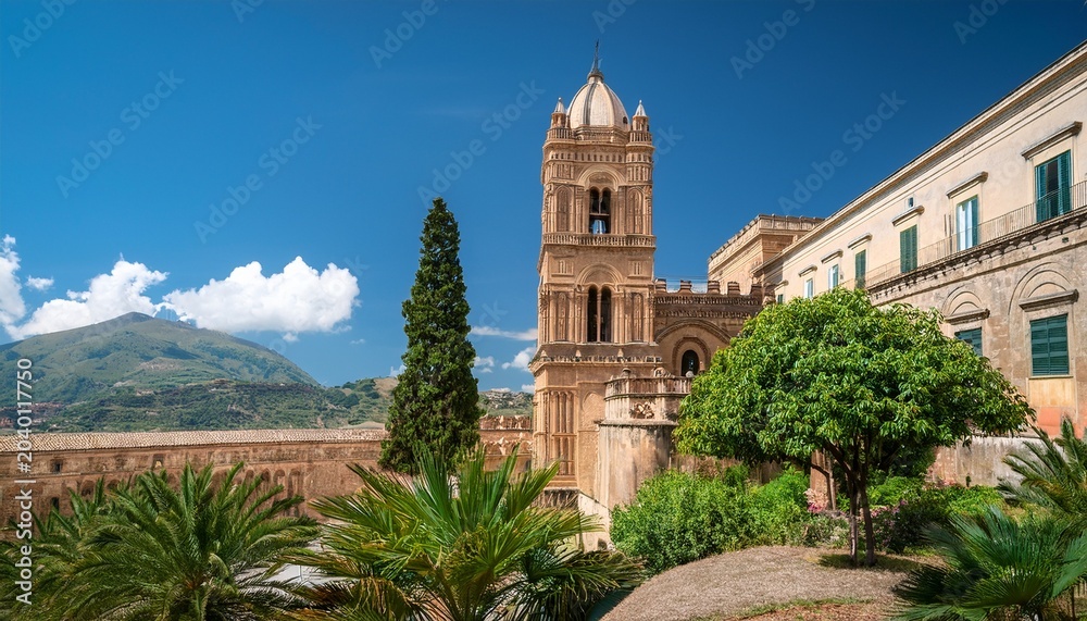 Fototapeta premium sicilian cathedral bell tower with stone architecture and greenery
