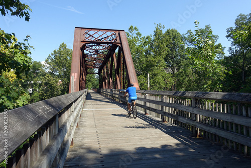 An historic iron truss bridge in the historic district (Collinsville) of Canton, CT (USA). Once an old railroad, it is now a recreational greenway for runners, bikers, and pedestrians.