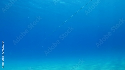 Rope underwater straight no end in space in blue water