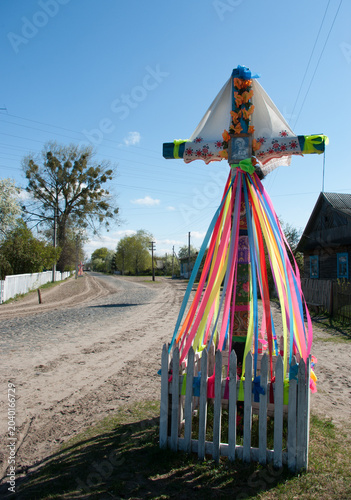 A wooden Orthodox cross, decorated with flowers and fabrics, on the road at the beginning of the village, protecting the village from evil spirits and evil. Ancient rituals and customs.