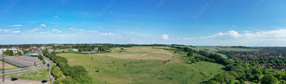 Fototapeta premium Aerial Ultra Wide Panoramic View of Residential District of Luton City During Clear Blue Sky. Drone Flight Above Urban City Streets of British City and Town of England Great Britain. 