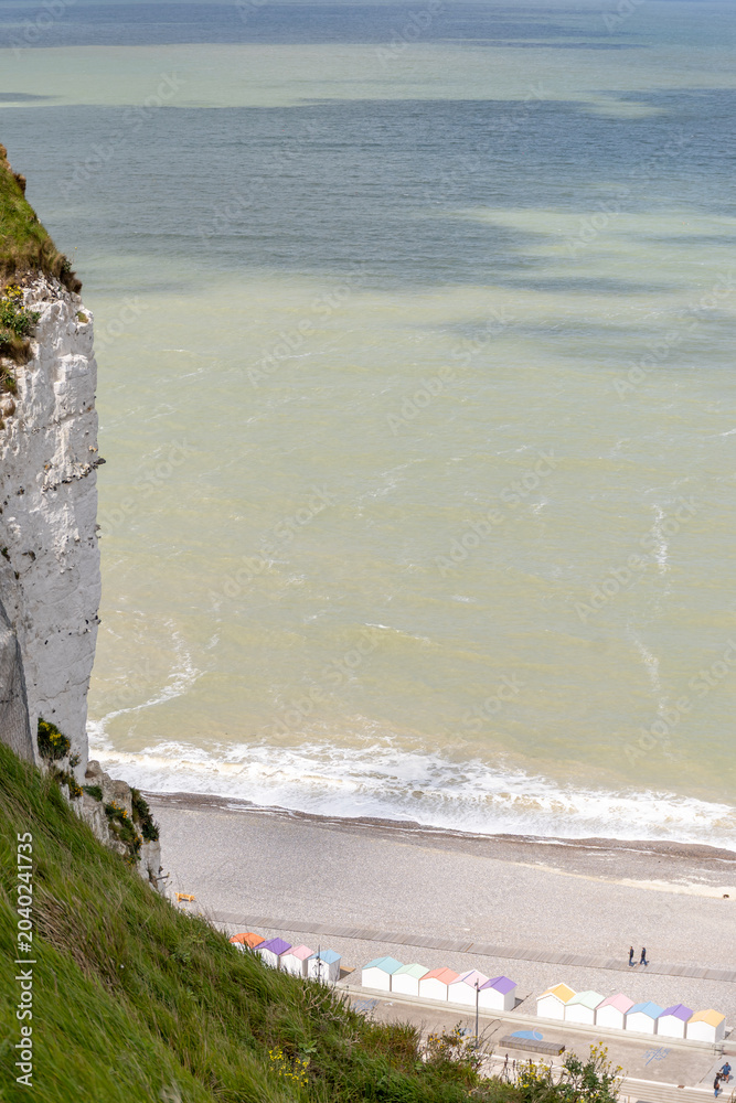 Obraz premium Views of ocean beach and colourful beach huts or cabins in Le Treport, seaside resort in Normandy, France, with white cliffs along English Channel, travel destination in France