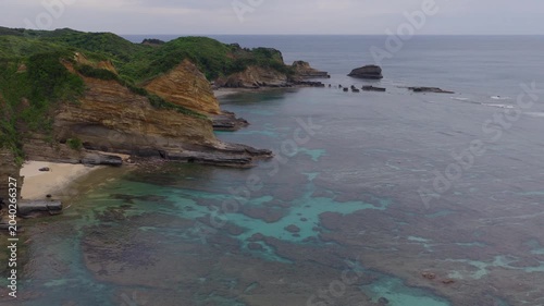 Flying over beach and coral reef in clear blue water on coast of Tanegashima Island, Japan