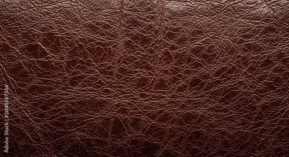 Fototapeta premium Brown leather texture background with cracked surface and natural light reflection