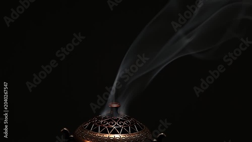 Incense sticks with white texture smoke on black background with copy space