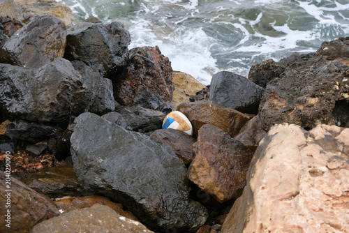 a volleyball among the rocks on the seashore