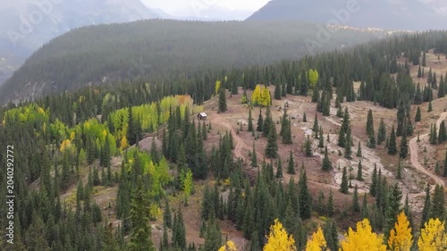 Aerial view of Colorado fall landscapes along Million Dollar Highway with picturesque cabin with views of fall foliage trees in San Juan Mountains during autumn season - 4K Drone