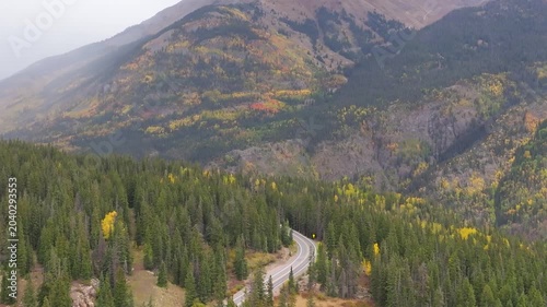 Aerial view of Colorado fall landscapes along Million Dollar Highway with views of winding roads and fall foliage trees in San Juan Mountains during autumn season - 4K Drone