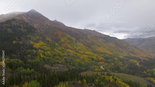 Panoramic aerial view of Colorado fall landscapes along Million Dollar Highway and Red Mountain Overlook with valley views of fall foliage trees in San Juan Mountains during autumn season - 4K Drone