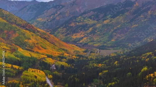Aerial view of Colorado fall landscapes along Million Dollar Highway and Red Mountain Overlook with valley views of fall foliage trees in San Juan Mountains during autumn season - 4K Drone