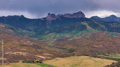 Panoramic aerial view of Colorado fall landscapes featuring mountain fall foliage trees while capturing beauty of Chinmey Rock and Courthouse Mountain in the San Juan Mountain wilderness - 4K Drone