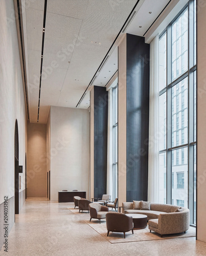 Luxury hotel lobby lounge featuring refined seating and warm architectural light and green courtyard