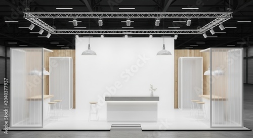 Modern minimalist exhibition stand with counter and display units in a large hall.