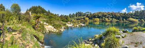Tableau sur toile Taupō, New Zealand, panoramic view of famous Otumuheke Stream hot pools, flowing into deep-green crystal-clear Waikato River at Spa Park
