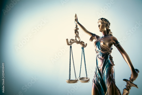 Statue of justice with scales of justice on a white background.