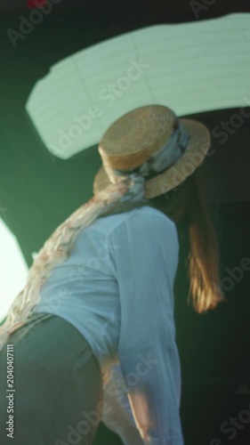 Nomadic woman packing, Woman with straw hat and ribbon veil readies for road trip with curiosity and nostalgia