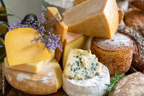 Fotografia Assorted gourmet cheeses with herbs.