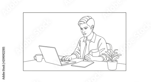 Young man working on laptop at desk with notebook and plant, focused on task
