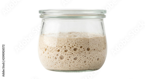 Active sourdough starter bubbling in clear glass jar
