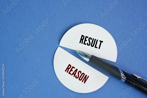 Foto Pen and paper cutting out the two words reason and result