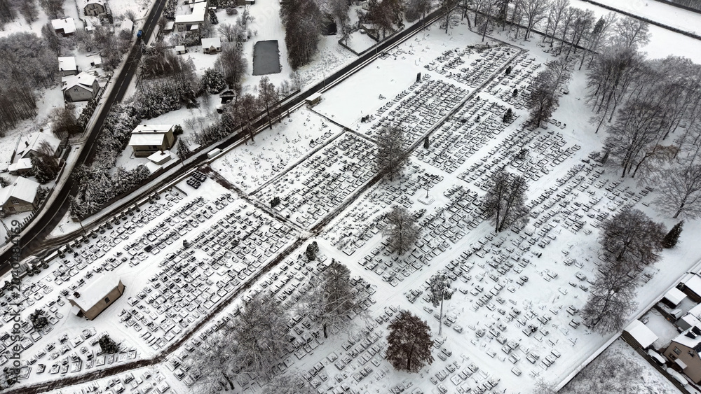 Fototapeta premium Winter wonderland view of a graveyard with a church