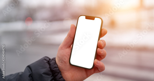 Smartphone mockup in hand on city street