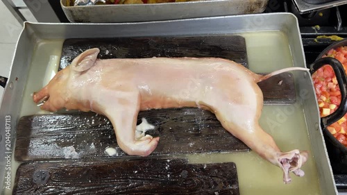 Chef salting a suckling pig before roasting