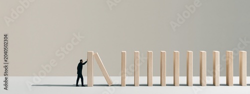 Person miniature stop falling wooden blocks domino effect light background
