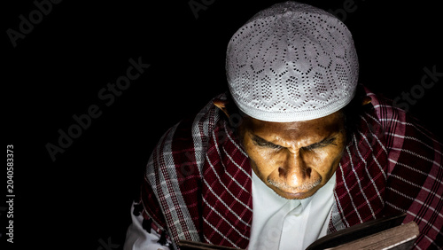 Photos a muslim man is reading the quran at night